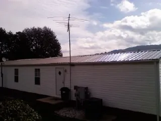 New metal roof on a single wide mobile home with a TV antenna in Kingston